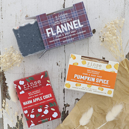 Three Fall Scented bars of soap with their packaging on a wooden surface