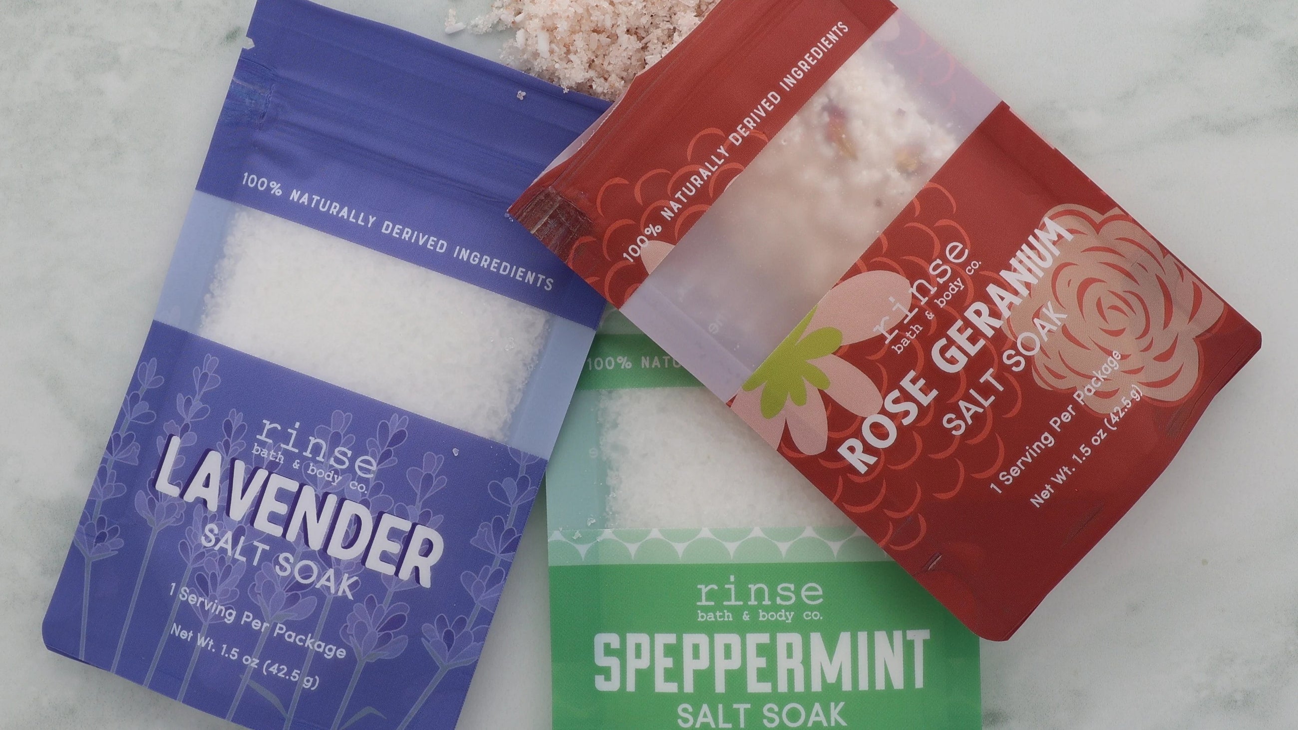 Rinse Lavender, Speppermint and Rose Geranium salt soak packets on marble