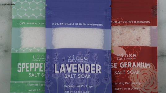 Rinse salt soak packets styled on a marble surface