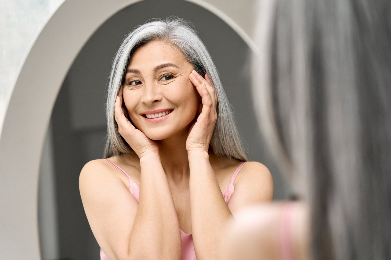 happy lady looking in mirror at skin